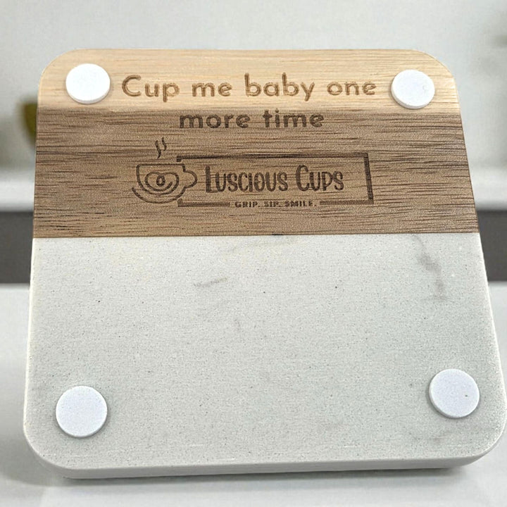 Sqaure wood and faux marble coaster with 'Cup me baby one more time' text and Luscious Cups branding.