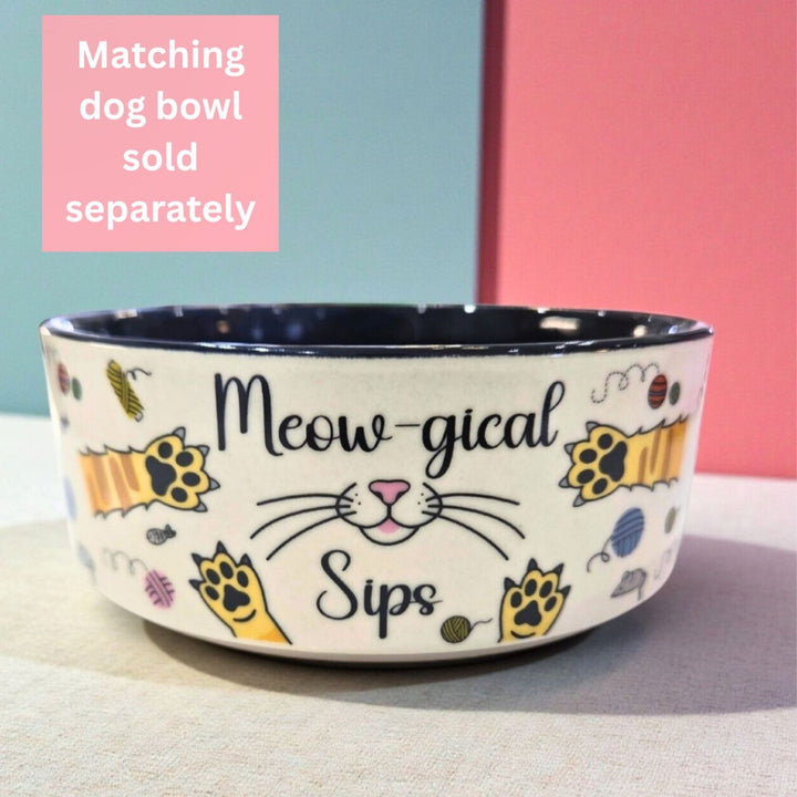 Cat-themed ceramic pet bowl with 'Meow-gical Sips' text on it. Matching the cat themed mug but sold separately.