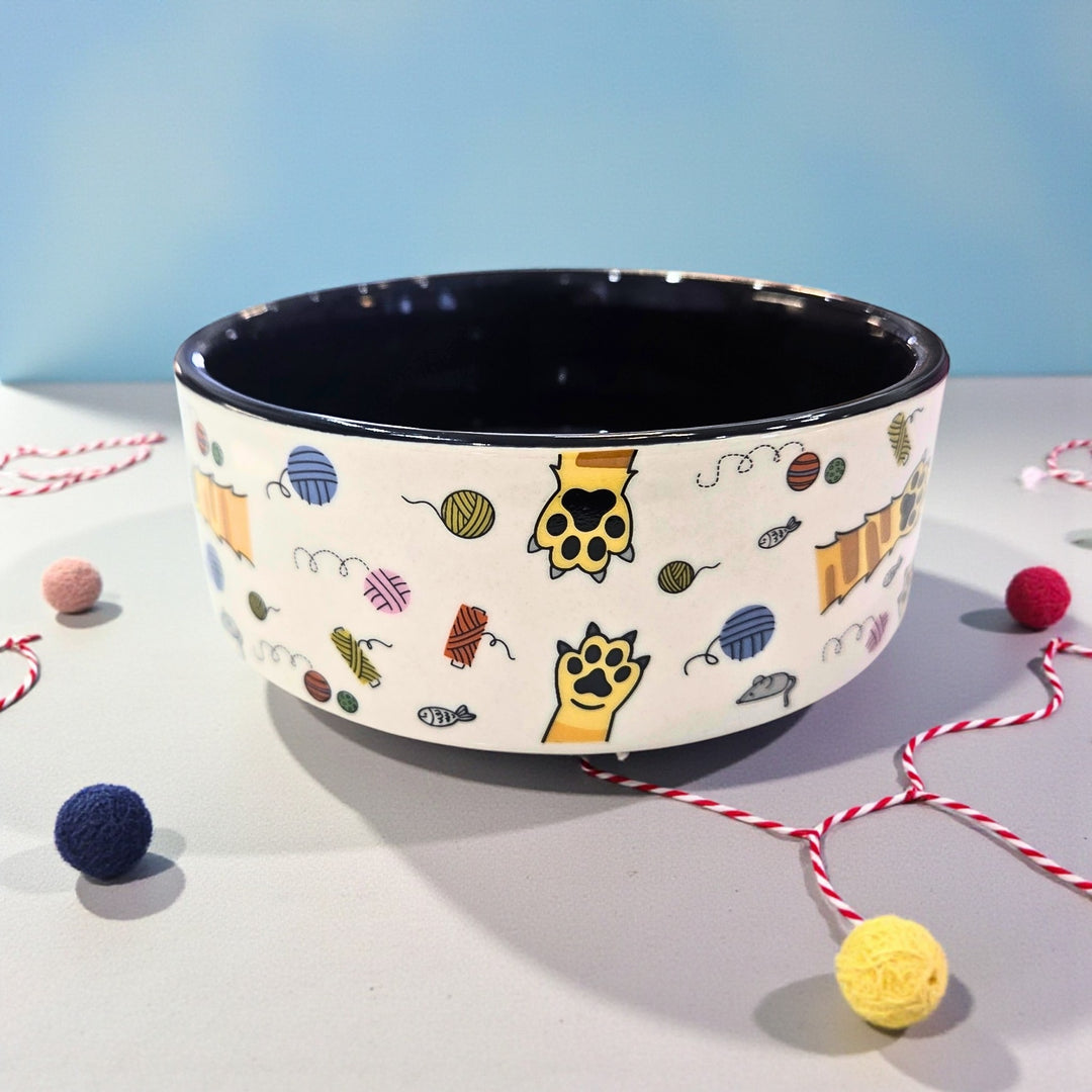 Ceramic bowl with cat-themed design on a light surface