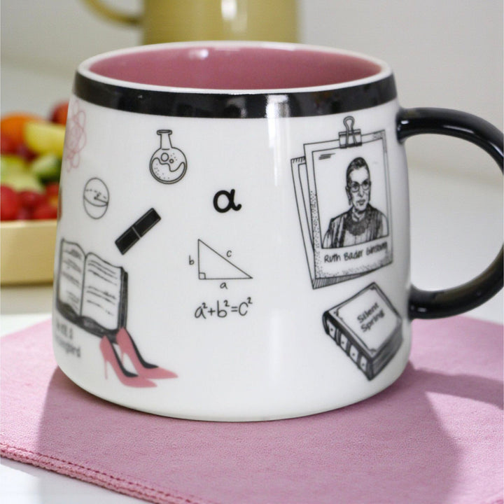 Ceramic mug with black handle and pink inside with illustrations including RBG.